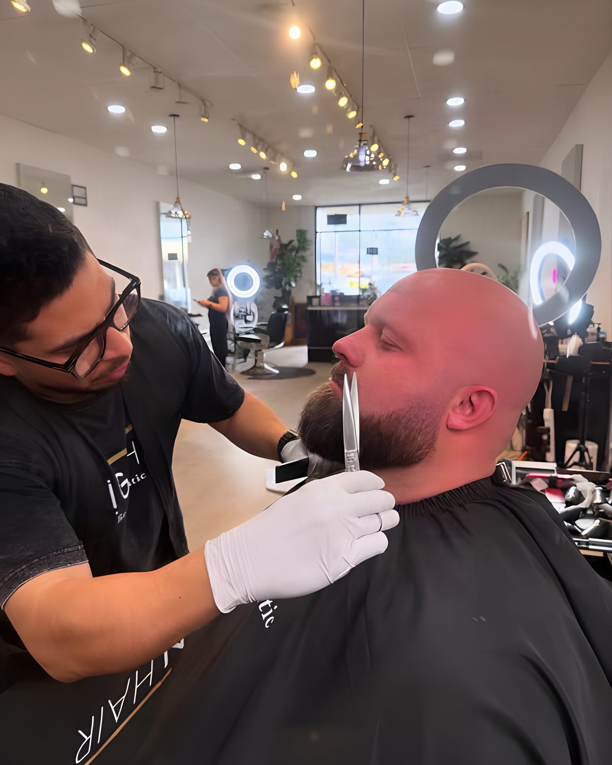 A barber at Align Hair Studio finishing a beard with a straight razor