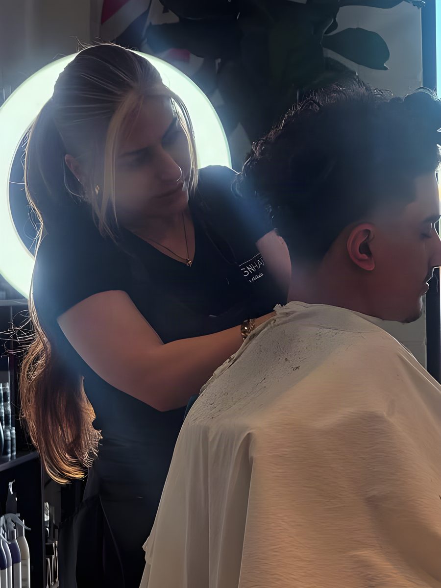 A stylist finishing a cut under the ring light